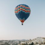 air balloon flying over rocky highlands