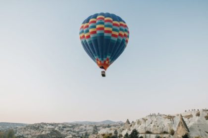 air balloon flying over rocky highlands